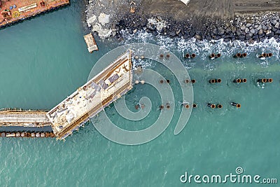 Drone view of a pier construction and piles. Working piers were built for the handling of passengers and cargo onto and off ships Stock Photo