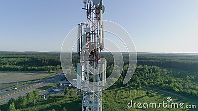 Drone view of telecommunication antenna system technician man dressed in uniform and helmet working on top stock video Drone view of telecommunication antenna system technician man dressed in uniform and helmet working on top stock video
