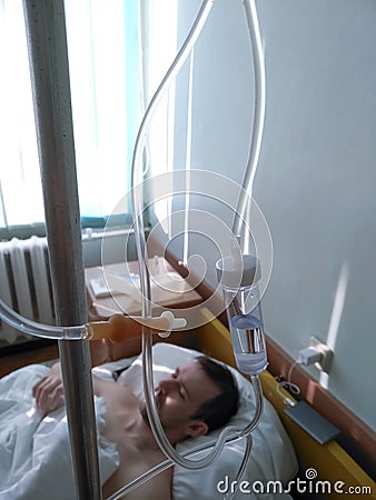 Drop counter against blurred background patient after surgery in hospital ward. Caucasia adult man is in the clinic for treatment Stock Photo
