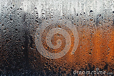 A drop of water on a windowpane. On the background is a gradient of colors from black to white through orange. Romantic and sad ba Stock Photo