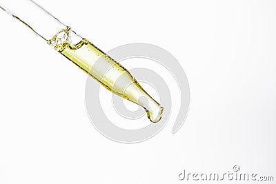 Dropper and drop of natural serum isolated on white. Stock Photo