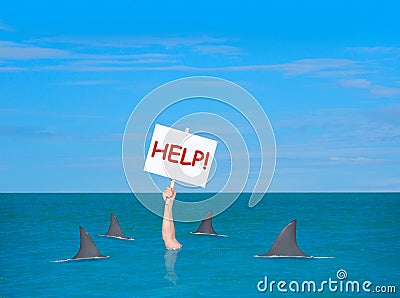 Drowning depressed man with help sign surrounded by sharks Stock Photo