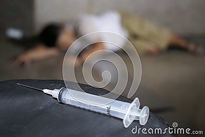 Drug addict and syringe on floor Stock Photo