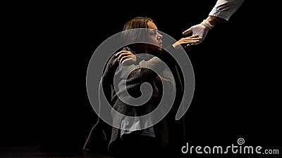 Drug addicted female taking doctors hand in protective glove, hope in future Stock Photo