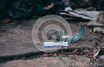 Old abandoned house and used plastic syringes. The problem of drug addiction in society Stock Photo