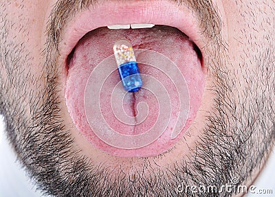 Drug pill on the man's tongue Stock Photo