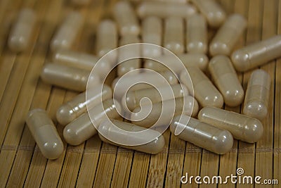 Drugs capsule. White pill medicines an a wooden Stock Photo