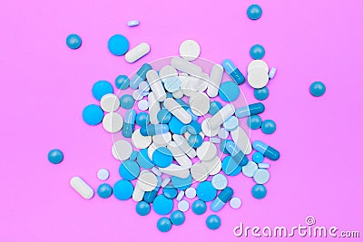 Drugs capsules and pills on pink background. Stock Photo