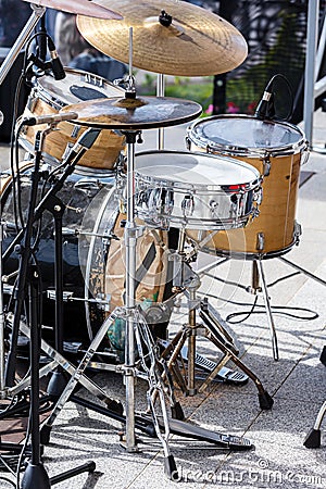 Drum kit with microphones standing on outdoor stage Stock Photo