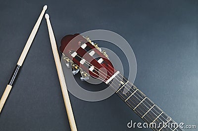 Drumsticks and guitar headstock close up. acoustic musical instrument Stock Photo