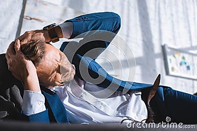 drunk businessman having headache while lying Stock Photo