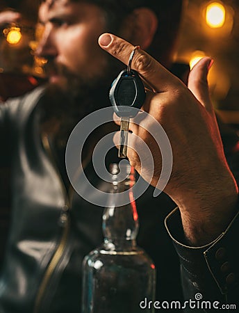 Drunk and hangover driver with car key in alcoholism problem and alcohol abuse concept. Man with beard holds glass of Stock Photo