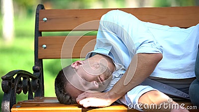 Drunk young man sleeping on bench in park, youth lifestyle, harmful addiction Stock Photo