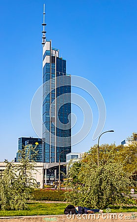 Drunken homeless individuals sleeping in Srodmiescie business district of Warsaw city center in front of Varso Tower in Poland Editorial Stock Photo