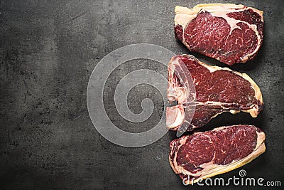 Dry aged beef steaks - ribeye, striploin, t-bone steaks on Black Stock Photo