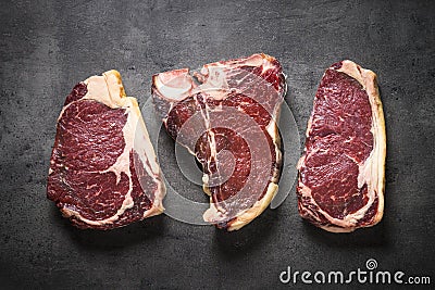 Dry aged beef steaks - ribeye, striploin, t-bone steaks on Black Stock Photo