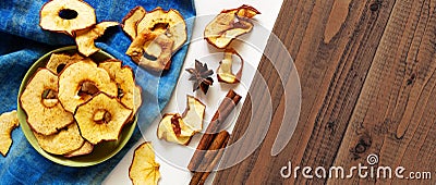 Dry apple chips and spices on white and brown wood background. Homemade baked sliced fruits, autumn fall healthy natural snack con Stock Photo