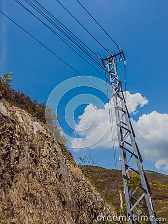 Dry asphalt empty automobile road with electric pole near rocks on a sunny summer day. Car travel trip concept Stock Photo