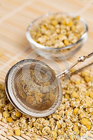 Dry chamomile with tea strainer Stock Photo