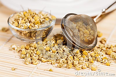 Dry chamomile with tea strainer and glass dish Stock Photo
