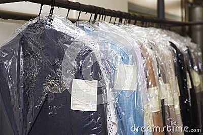 Dry cleaning things hanging in a row Stock Photo