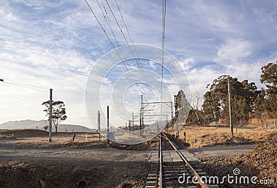 Dry Countryside with Rural Gravel Road Crossing Railway Tracks Stock Photo