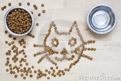 Dry food for cats. Two bowls. Wooden surface. Cat shape Stock Photo
