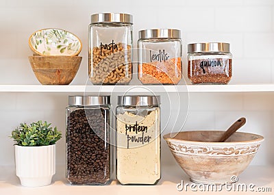 Dry food ingredients in glass jars on a kitchen shelf Stock Photo
