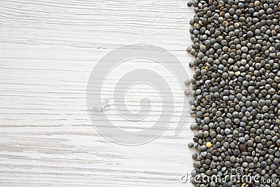 Dry green french lentils on a white wooden background, top view. Overhead, from above. Copy space Stock Photo