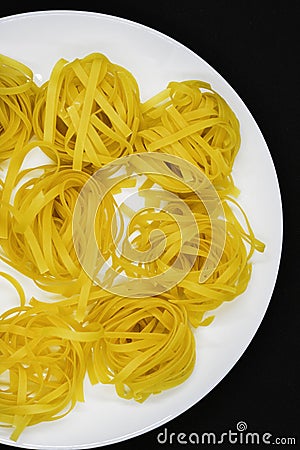 Dry pasta on a white plate. Wheat pasta Stock Photo