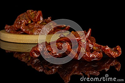 Dry red cherry tomato isolated on black glass Stock Photo