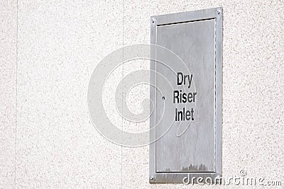 Dry riser steel silver box architrave on building wall Stock Photo
