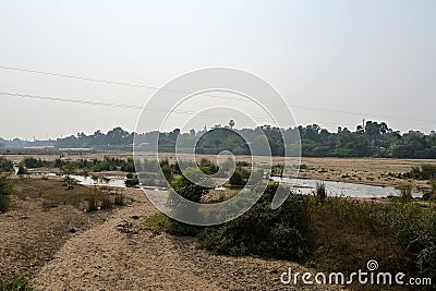 Dry river bed of the Phalgu or Niranjana in winter, with Bodhgaya and the dome of the Mahabodhi Temple in the distance Stock Photo