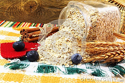 Dry rolled oatmeal flakes in bottle with blueberry cinnamon and oats ears Stock Photo