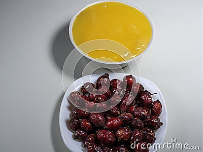 Dry rose hips and honey in a white plate. Stock Photo