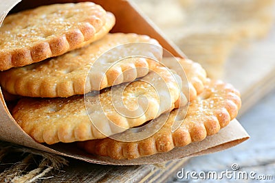 Dry salty cracker cookies in a wrapping paper. Crunchy savory crackers snack idea for kids or adults. Rustic stile. Closeup Stock Photo