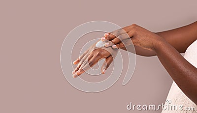 Dry Skin Treatment. Unrecognizable African American Woman Applying Moisturizing Cream On Hands Stock Photo