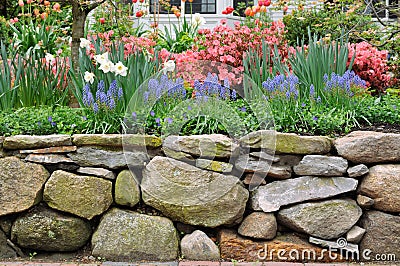 Dry Stone Wall and Colorful Garden Stock Photo