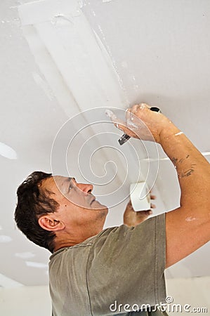 Dry waller working at the ceiling Stock Photo