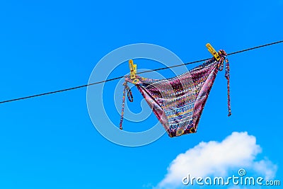 Drying female swimsuit hanging on rope against blue sky Stock Photo