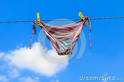 Drying female swimsuit hanging on rope against blue sky Stock Photo