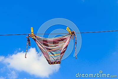 Drying female swimsuit hanging on rope against blue sky Stock Photo