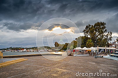 View of tthe harbor and beach in Megalo Pefko Nea Peramos under a dramatic sky at sunset,Attica,Greece Stock Photo