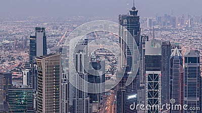 Dubai Downtown skyline futuristic cityscape with many skyscrapers and Burj Khalifa aerial night to day timelapse. Stock Photo