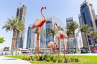 Big flamingos statues on Dubai Creek Harbour promenade with skyline in the background Editorial Stock Photo