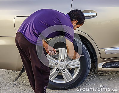 A man working with a car wheel Editorial Stock Photo