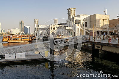 Al Seef Village at Bur Dubai. Al Seef old style area with people. Wooden piers with big dhow boat. Editorial Stock Photo