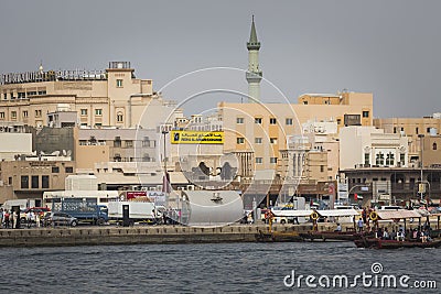 DUBAI, UAE - JANUARY 18, 2017 : Dubai Creek. Small ships and dhows line the Deira side of the creek while abras cross from Bur Du Editorial Stock Photo