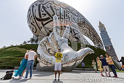 Dubai, UAE - March 28, 2022: Tourists taking photos in front of unique modern exterior of Museum of The Future in Dubai Editorial Stock Photo