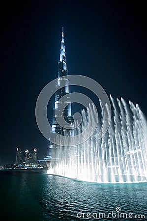 Wonderful evening fountain show in Dubai downtown with famous tower on the background Editorial Stock Photo